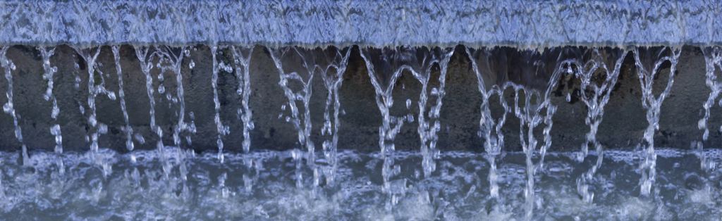 L'acqua scorre lungo un muro di cemento.